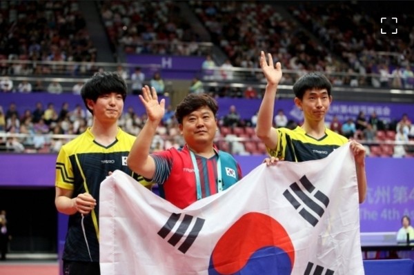 MD22체급 결승전 모습과 우승 직후 모습. 김정중 코치(가운데)와 김기태(좌), 김창기(우) 선수가 관중들에게 인사하고 있다. 